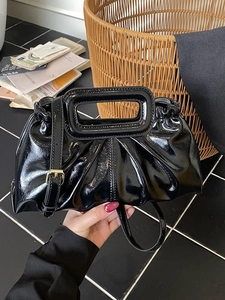 Glossy black pleated tote bag with cut-out handles and adjustable golden shoulder strap