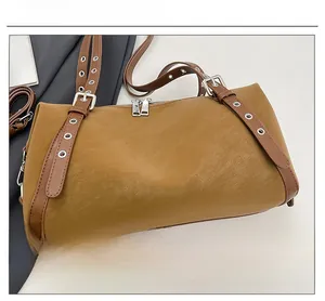 Detailansicht der braunen Retro-Tasche mit Ösenriemen und Silber-Reißverschlüssen