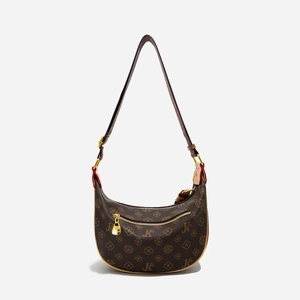 Close-up of brown monogram crescent bag featuring premium leather and gold zipper detail