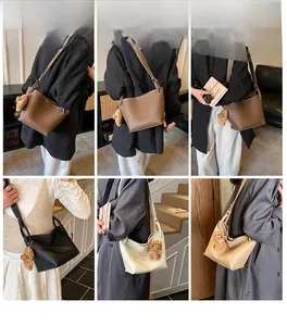 Détail de sacs seaux minimalistes en quatre couleurs avec breloques d'ours en cuir