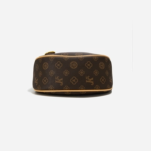 Detailed macro view of retro monogram canvas and golden metal zipper on a hobo bag