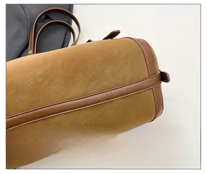 Nahaufnahme von braunem Leder mit Litschi-Textur und feinen Nähten an der Zylindertasche