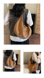 Dettaglio del ricamo a margherita e delle scritte su una borsa a tracolla marrone