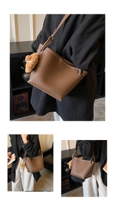 Détail du sac seau marron à motif litchi avec un adorable pendentif ours en peluche