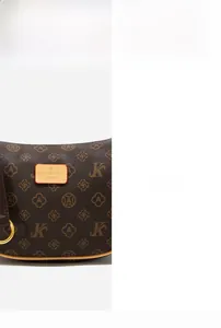 Close-up of brown monogram handbag with leather logo patch and gold-tone metal ring detail