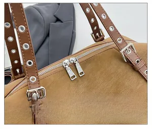 Detailansicht der glatten Metall-Doppelreißverschlüsse und Nietengurte an beiger Ledertasche