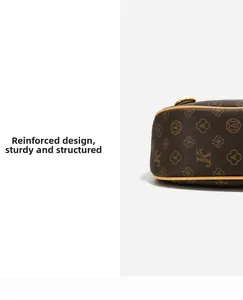 Detail of the structured frame design and monogram pattern on this brown crossbody bag