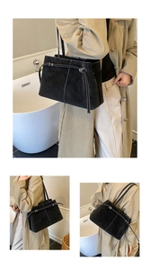 Detail of black matte bucket bag featuring white contrast stitching and tie-closure