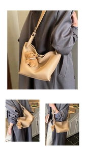 Détail du sac seau beige en cuir à motif litchi avec charmant ours marron