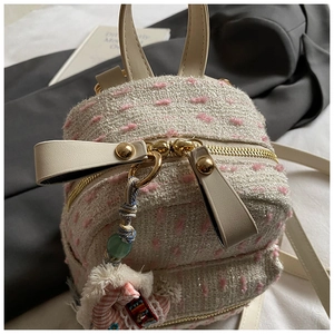 Detail of pink tweed mini backpack featuring glitter threads and a cute pony charm
