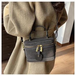 Detail der dunkelgrauen Beuteltasche mit Krokoprägung, kombiniert mit einem Wollmantel