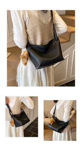 Détail du sac seau noir grainé avec surpiqûres blanches et pendentif ours en peluche