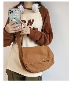 Brown vintage canvas messenger bag with large flap and wide strap shown on model