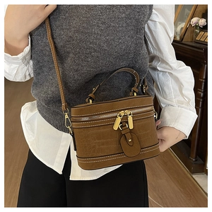 Detailansicht der braunen Kroko-Eimer-Handtasche mit hochwertigem goldenem Reißverschluss