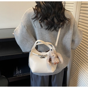 Detailed view of white litchi pattern leather handbag with silver lock and rabbit charm