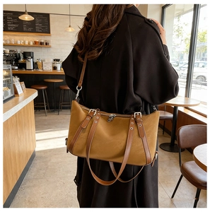 Details der Vintage-Tasche in Karamell mit Lederriemen und Metallösen-Verzierung
