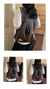 Detail of dark brown faux leather backpack with silver chain and heart charm