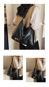 Detail of black PU leather tote bag with thick silver metal chain and rectangular buckle