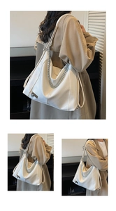 Detailed view of white PU leather tote bag with silver chain and heart charm detail