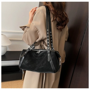 Nahaufnahme der schwarzen matten Ledertasche mit silbernen Ösenriemen und Metallzipper