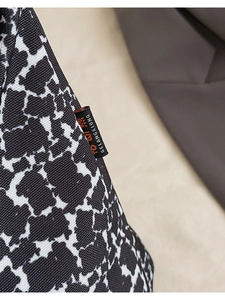 Close-up of fabric bucket bag with black and white print and side logo tag detail