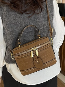 Braune Eimer-Tasche mit Krokostruktur, weißen Nähten und praktischem Haltegriff