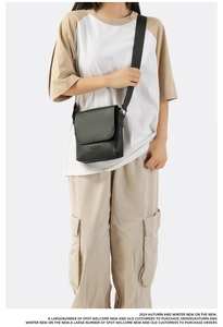 Detail of black crossbody square bag with HEYMISTER embossed logo and flap closure