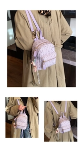 Detail of purple tweed mini backpack featuring gold hardware and a cute doll charm
