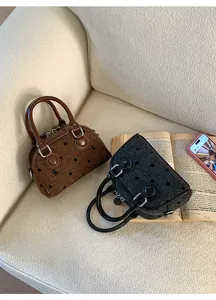 Close-up of mini tweed Boston bags with black polka dots on a cozy sheepskin sofa