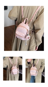 Detail of pink tweed mini backpack featuring leather trim and woven tassel accessory