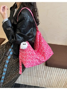 Detail of pink leopard print tote bag with plush monster charm worn on the shoulder