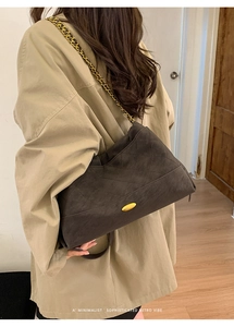 Detailed view of coffee brown quilted suede tote bag with elegant gold chain strap