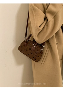 Brown fabric Boston bag with black polka dots styled on a long wool coat