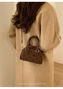 Close-up of retro polka dot bowling bag with bow detail and textured tweed fabric
