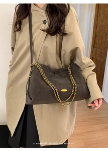 Detail of retro quilted crossbody bag with gold chain handle and vintage metal buckle