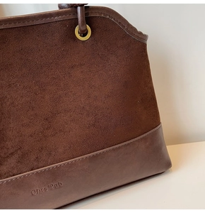 Détail macro du mariage de daim marron foncé et cuir lisse avec logo en relief