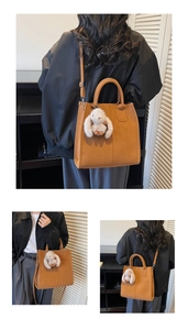 Macro detail of caramel tote bag showing stitching, handles and plush rabbit charm