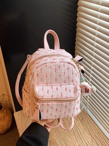 Women's pink tweed mini backpack with orange pom-poms and leather straps for winter style