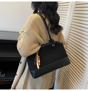 Détail du sac cabas vintage noir en daim avec charm ethnique en perles de bois