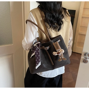 Brown leather tote bag detail with fashion silk scarf and cute plush bunny pendant accessory