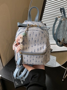 Light blue tweed mini backpack with horse pendant shown from front and back views