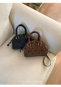 Detail of mini tweed handbags in black and brown with bow embroidery on a sofa