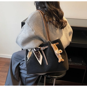 Detail of black suede tote bag with brown leather straps and fashion scarf accessory