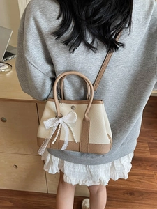 Canvas contrast garden bag with lace bow and pearl charm shown on model shoulder