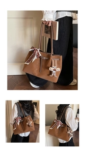 Detail of brown tote bag with decorative scarf and plush rabbit charm in home setting