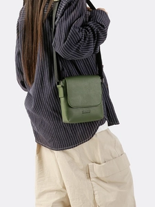 Dark green textured leather crossbody square bag with adjustable wide fabric strap