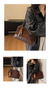 Gros plan du sac fourre-tout en daim marron avec perles en bois et logo en relief