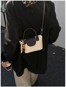 Détail du sac à bandoulière crème et marron avec perles en bois et sangle longue