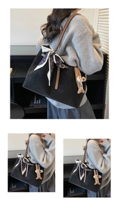 Close-up of black matte tote bag featuring silk scarf detail and cute plush charm