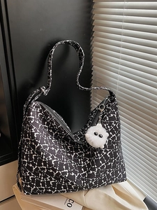 Minimalist canvas hobo bag with black white floral print and white plush charm on it
